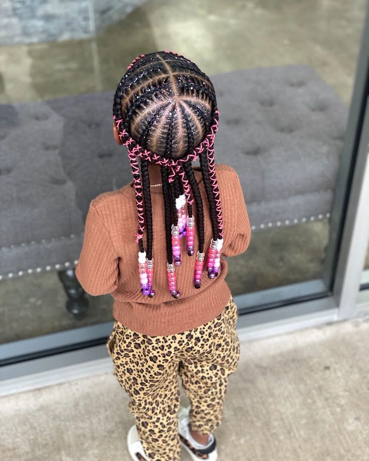 Feed in braids decorated with ribbon woven through the braids on a little girl.