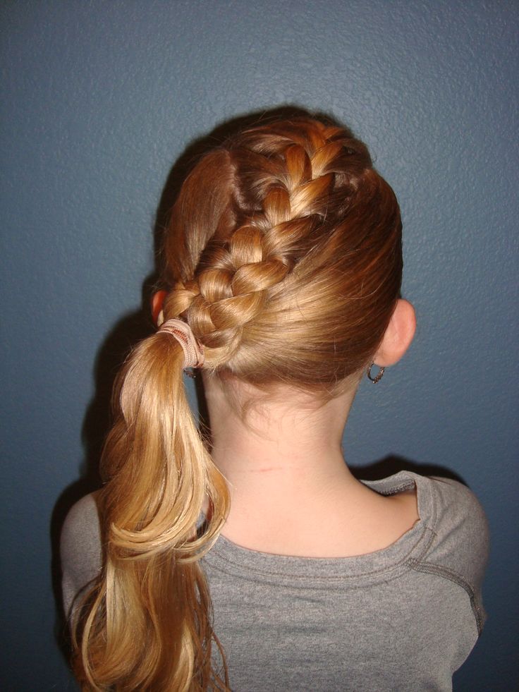 A child wears a French braid swept to one side, gathered into a low ponytail.