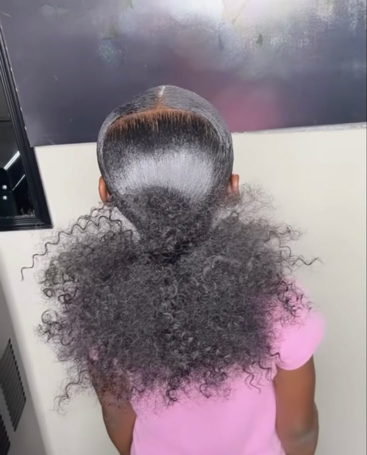 Young black girl with a sleek low ponytail with curls