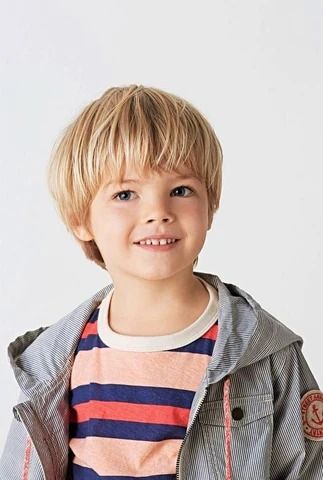 : Close-up of a young boy with a bowl cut haircut, hair trimmed evenly around the head with a full, straight fringe.