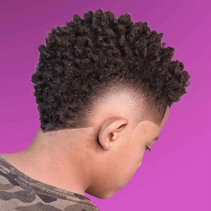Side and back view of a young boy with a Frohawk haircut, coily hair styled fuller and raised through the center, blending into a faded, closely cropped side.