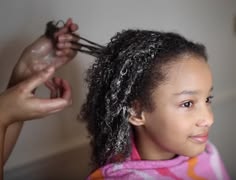 A hand finger detangling a child's  hair  