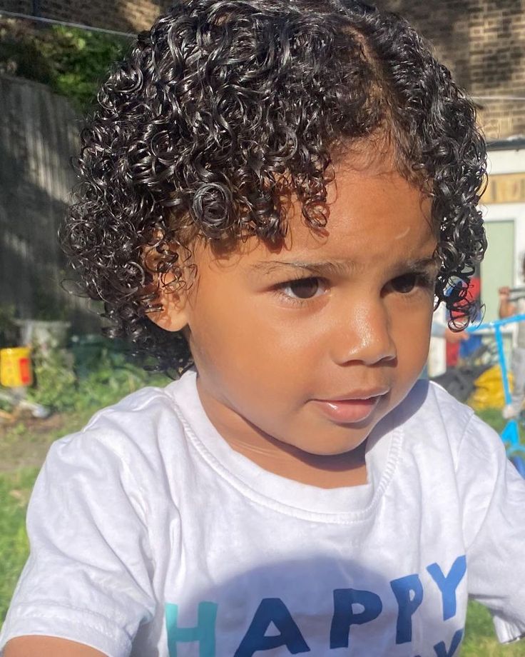 Close-up of a toddler with naturally defined, glossy curls styled as a wash-and-go look.