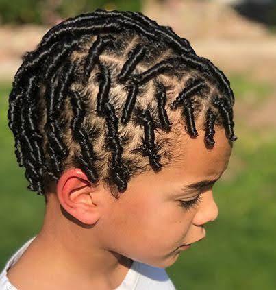 Overhead close-up of a young boy with comb twists, smooth, defined twist sections radiating across the scalp with crisp parting lines.