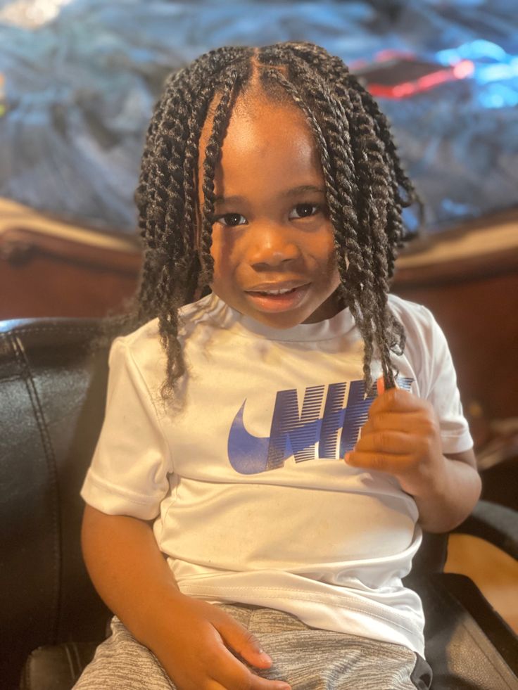 A young boy smiling with long, healthy two-strand twists