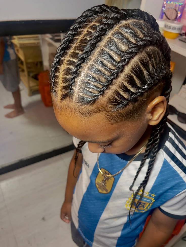Overhead close-up of a young boy with flat twists, neat twisted rows lying close to the scalp in a defined pattern.