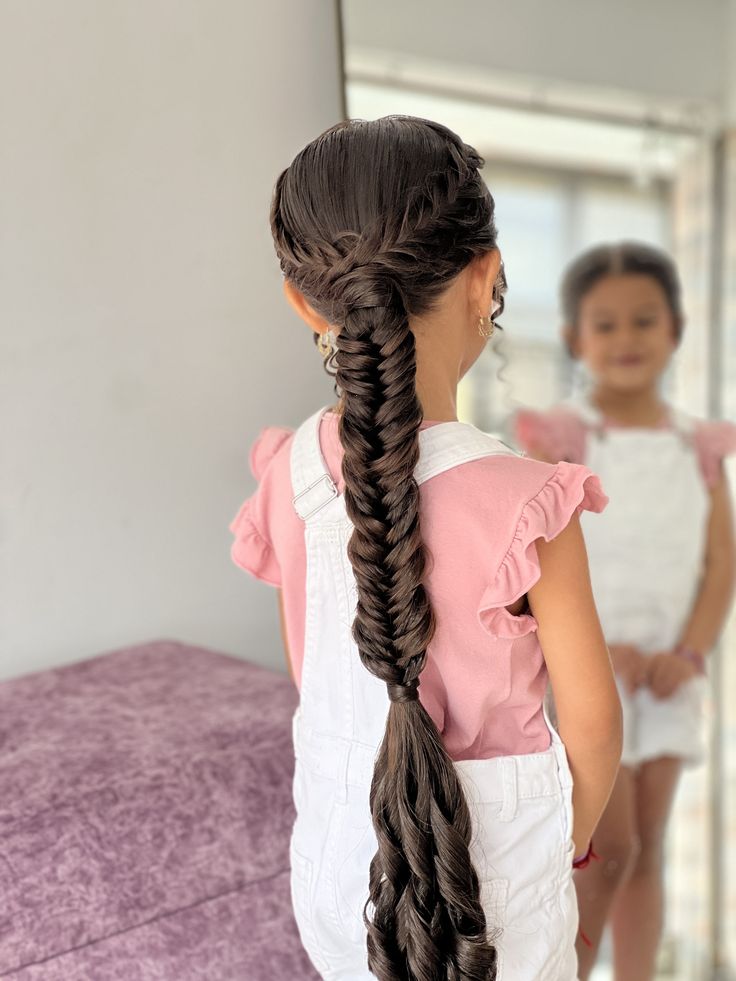 Girl wearing an intricate fishtail braid with fine, woven sections