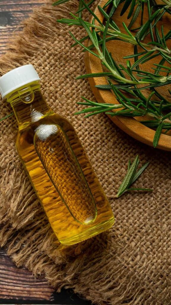 Flat lay of rosemary oil and rosemary leaves for a healthy comfortable scalp