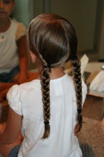 Braided pigtails with matching bows, twisted back into two simple braids