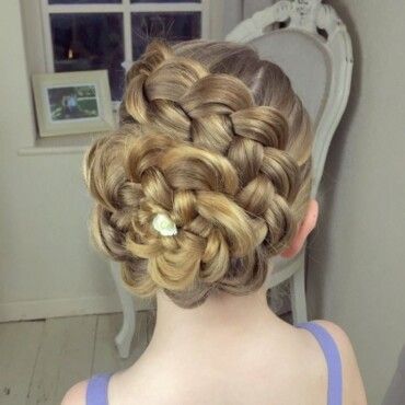 Child with a braided flower bun updo, hair swept into a spiral rosette at the back