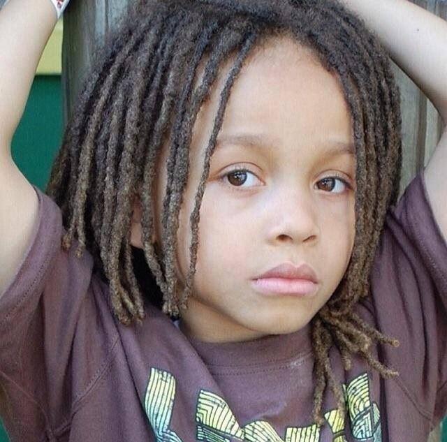 Close-up of a young boy with shoulder length freeform loc