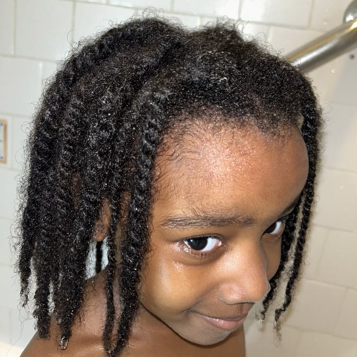 Close-up of a child's twisted hair showing new growth and frizz at the roots, a sign a takedown is due
