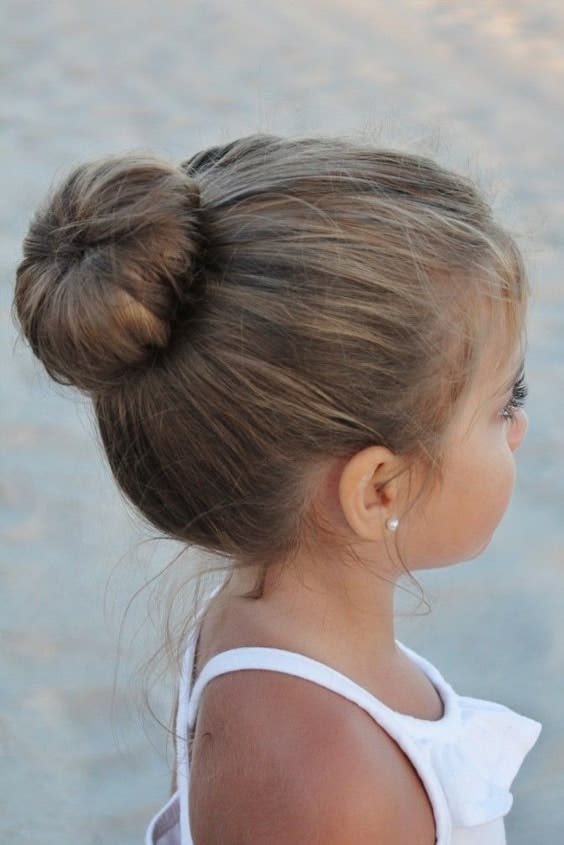 Child wearing a high top knot bun for a clean, quick school-morning hairstyle