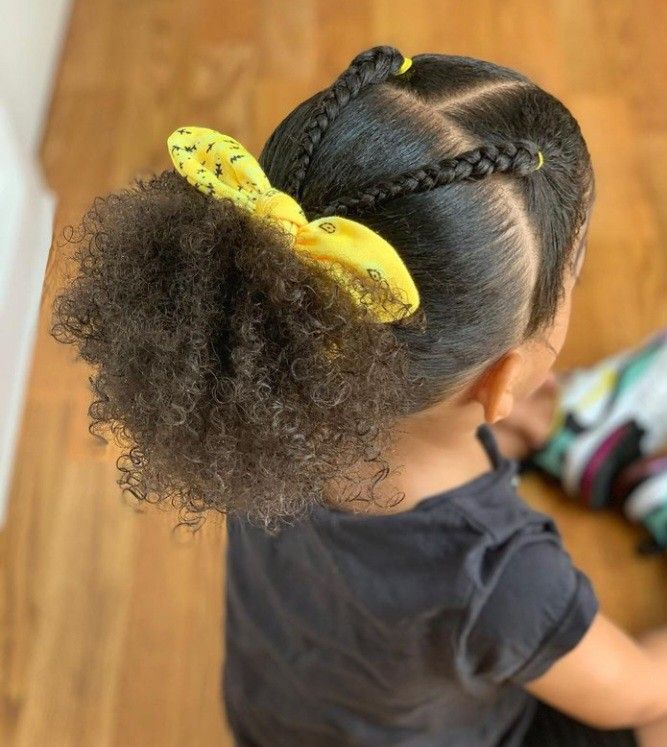 Girl with natural hair gathered into a softer low puff near the neck