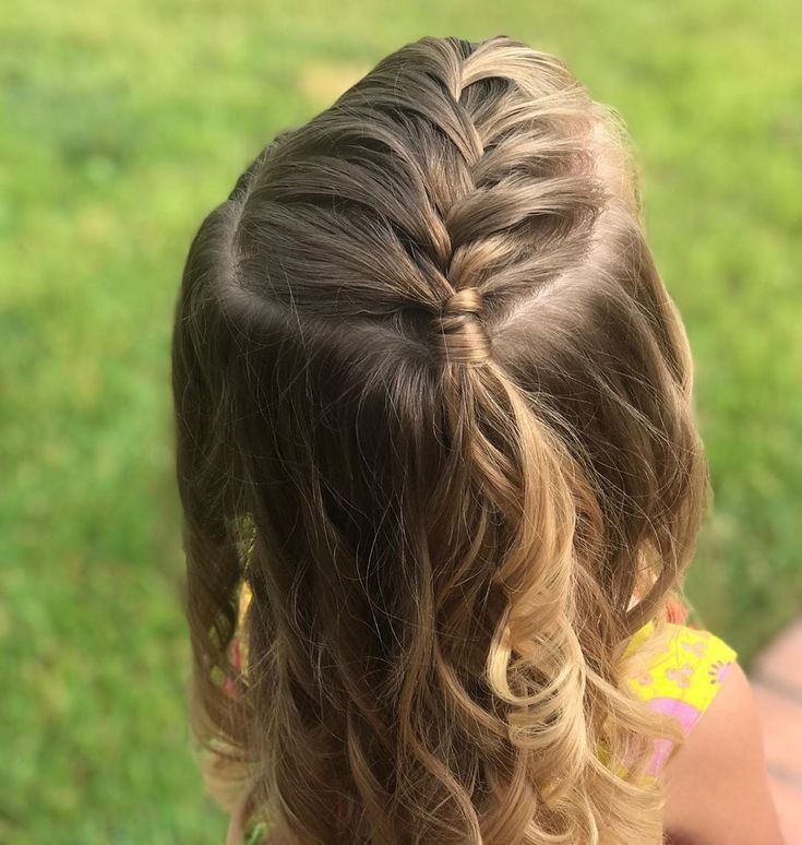 Child wearing half-up French braids that join at the back with hair left loose below