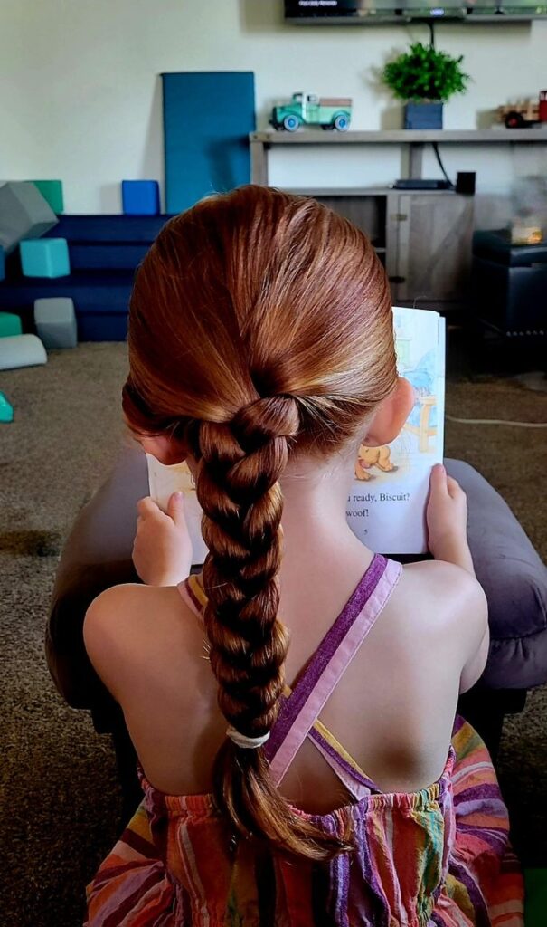 Low braided ponytail sitting at the nape of the neck for a relaxed look