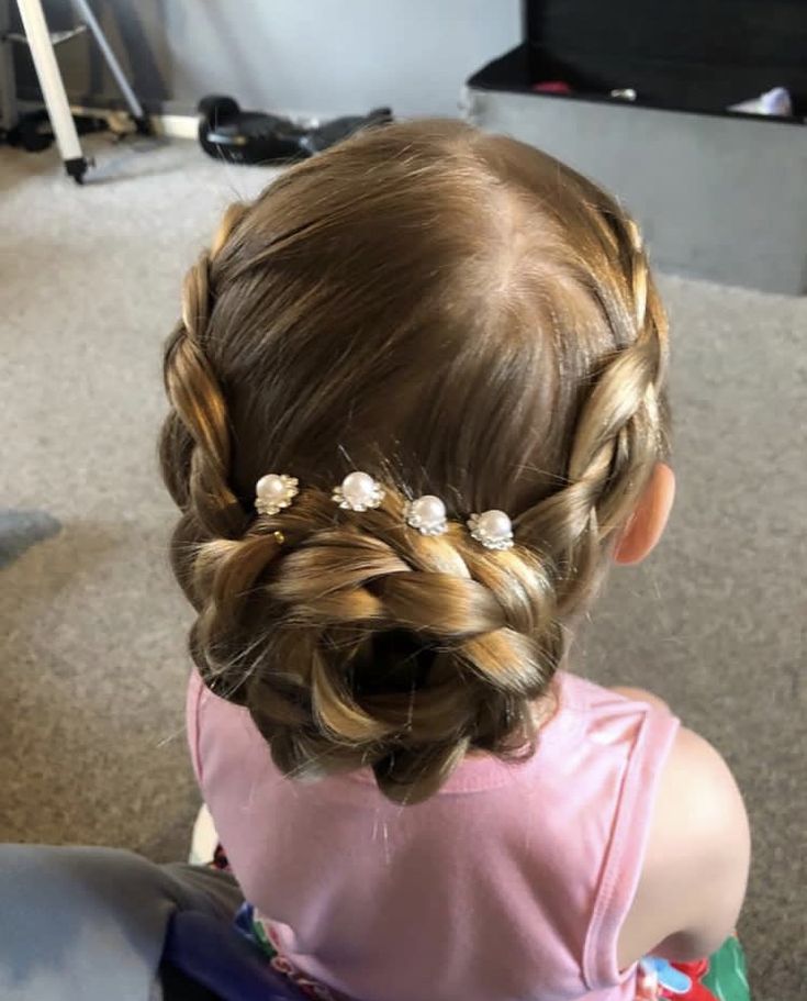 Toddler with a rose-patterned bun accented with pearl hairpins