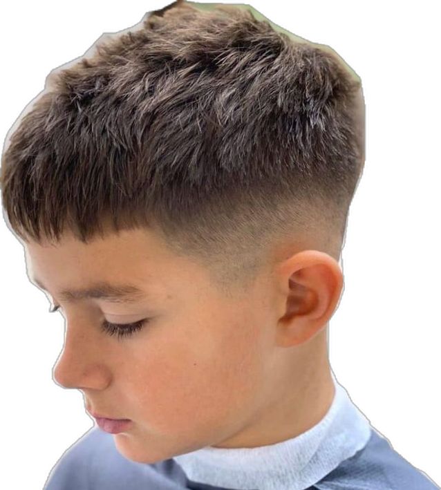 Side profile close-up of a young boy with an Edgar fade haircut, a blunt, straight-across fringe on top blending into a low fade on the sides.