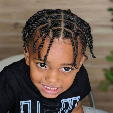 Close-up of a young boy smiling, hair styled in two-strand twists, individually twisted sections with a defined rope-like pattern.
