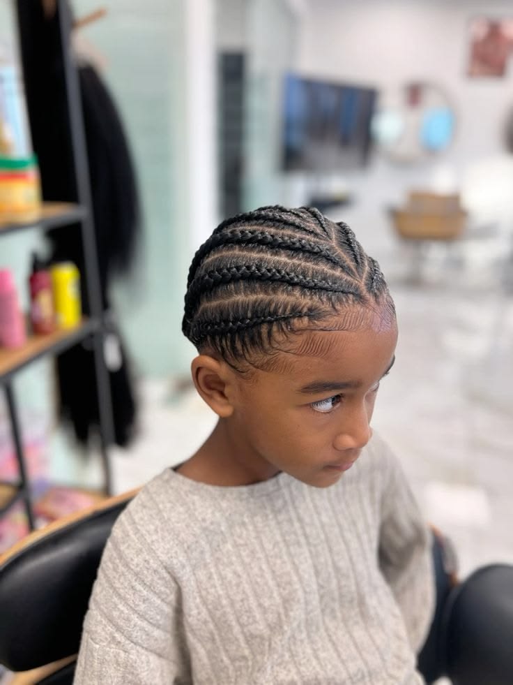 Side profile close-up of a young boy with cornrows