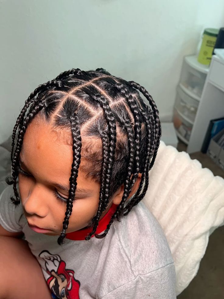 Side profile close-up of a young boy with box braid. braided with his hair