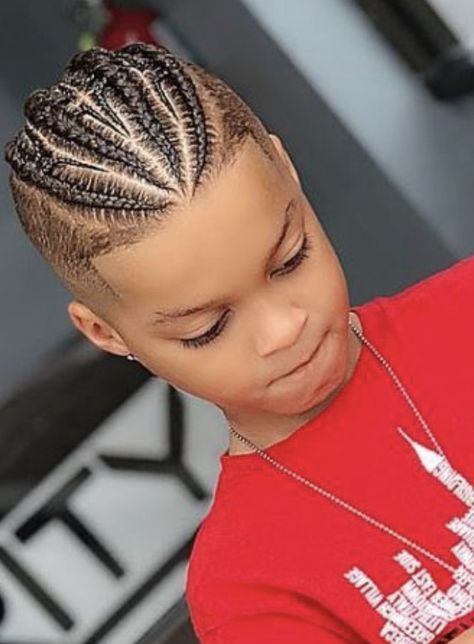 Overhead close-up of a young boy with a braided mohawk, cornrows concentrated into a fuller center section with closely faded sides.