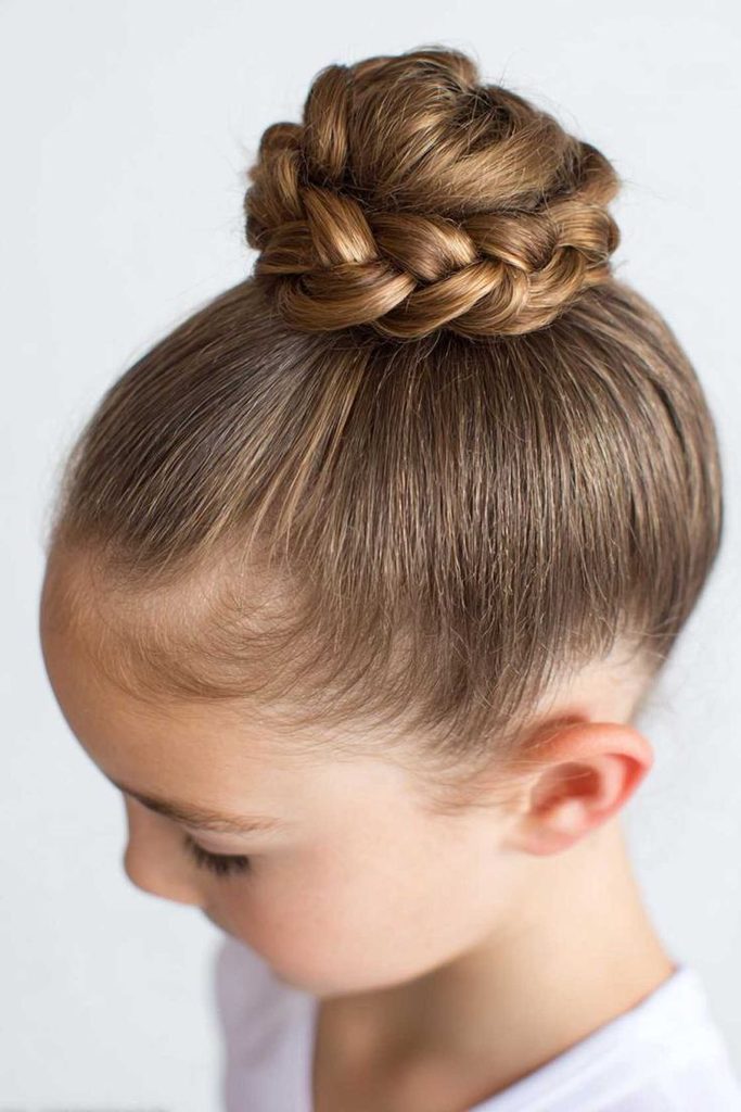 Girl with a smooth ballerina bun wrapped with a braid at the base