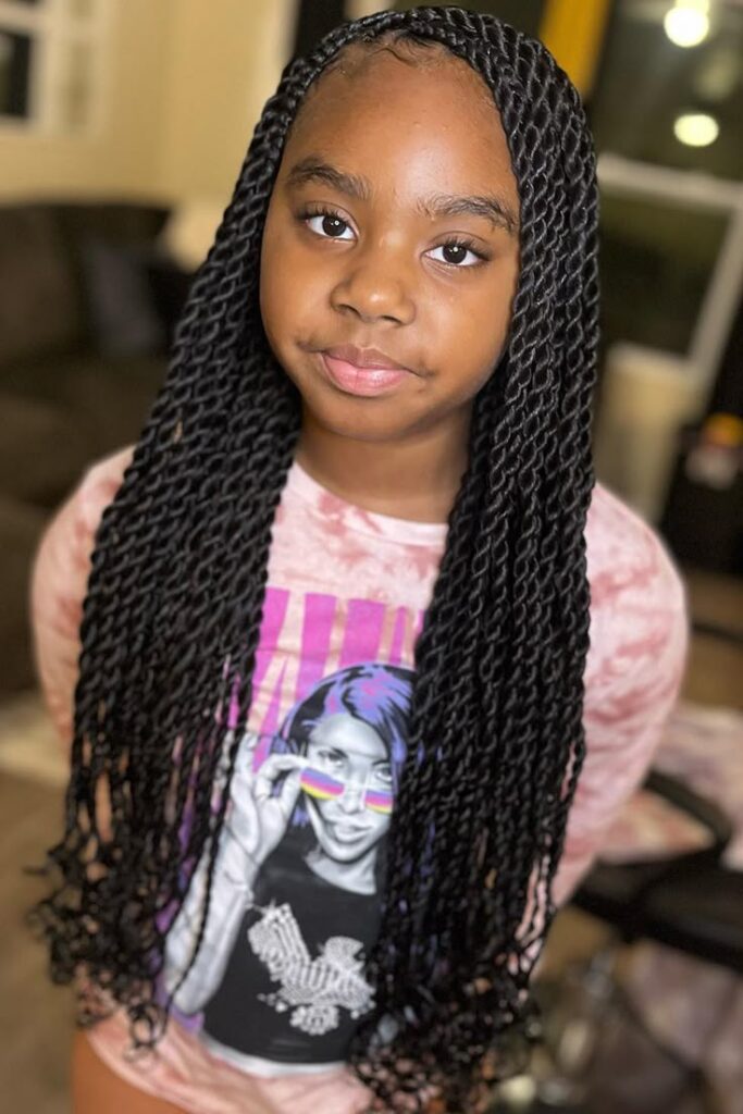 Back view of a child's cornrows ending in colorful beaded braids