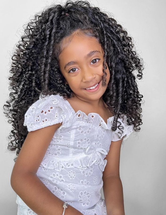 Smiling girl with tight springy curls from a straw set