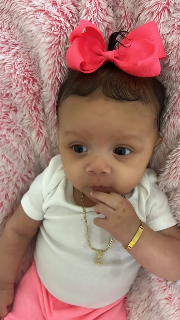 Cute  baby wearing a small pink bow clip