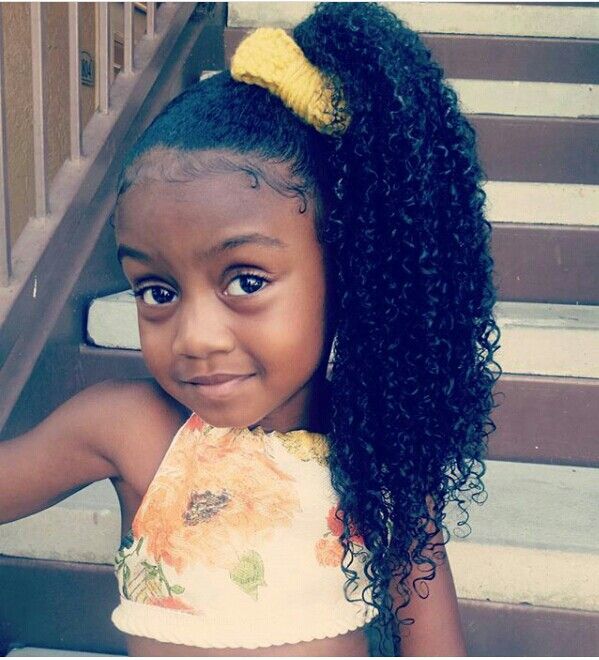 Girl with long curly side ponytail and yellow bow