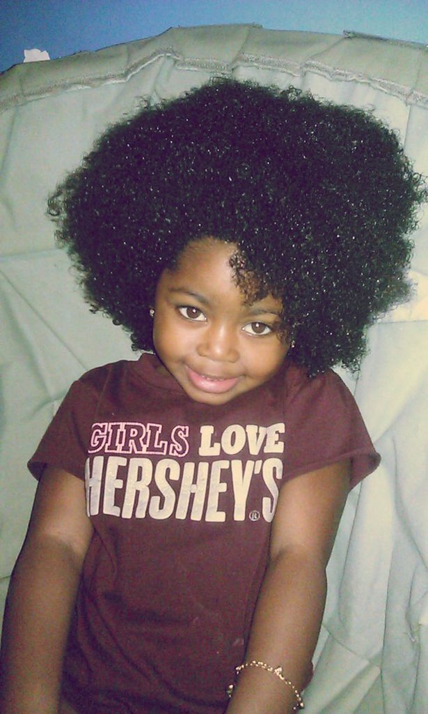 Child with a full natural wash-and-go curly afro