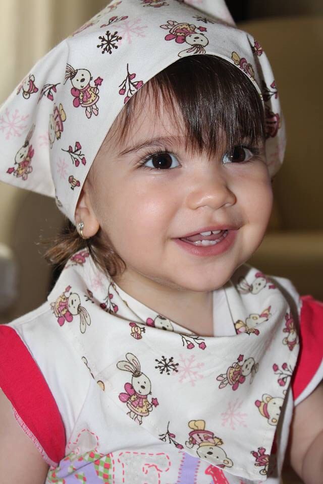 Baby wearing a printed bandana headscarf