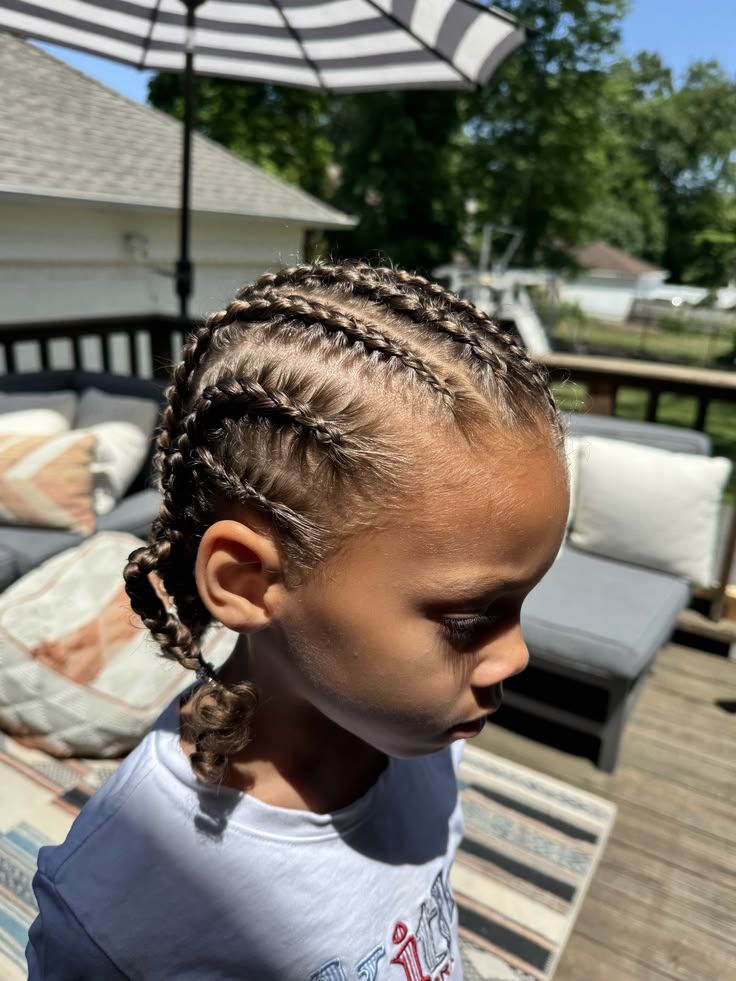 Child with braided protective hairstyle outdoors