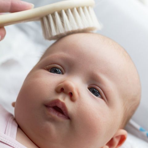 Soft brush gently used on a baby's scalp for cradle cap