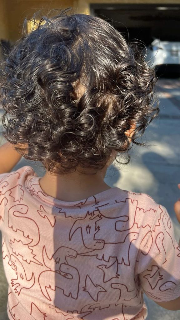 Toddler with natural curly hair left in a wash and go style