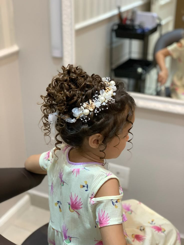 Young girl with a curly updo accented with pearl and gold floral pins