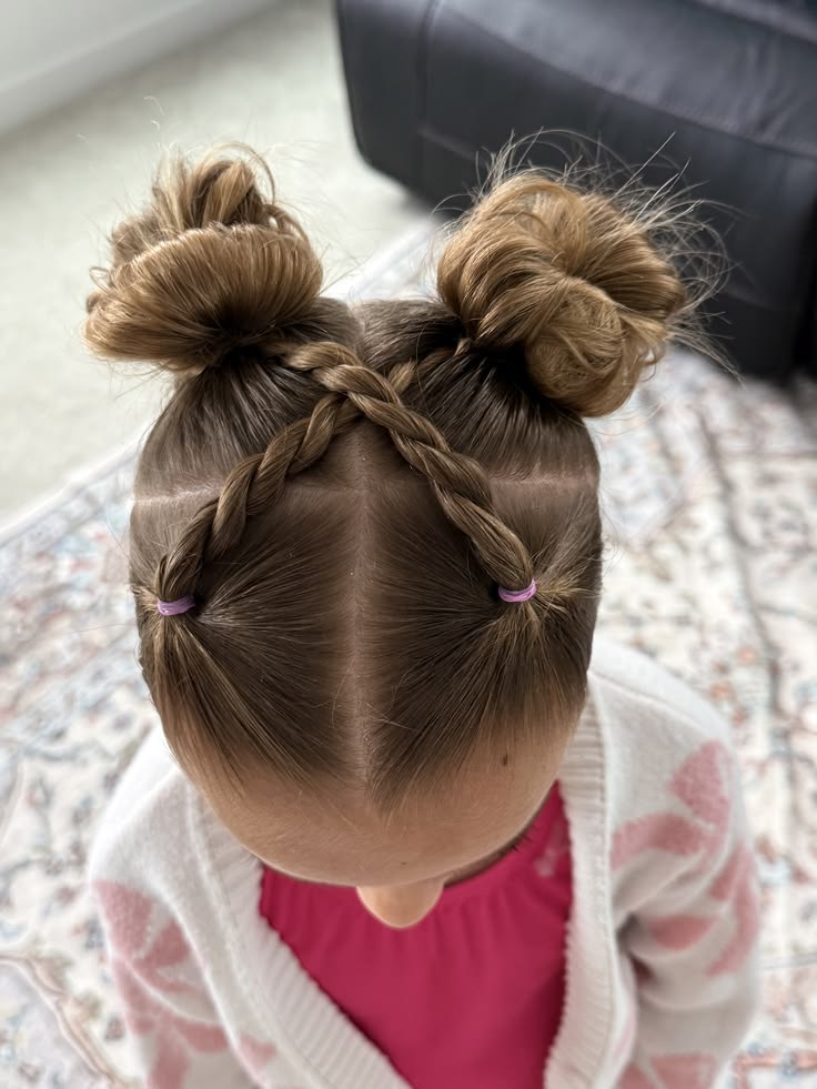 Overhead view of a girl with two space buns and crisscrossed twists across the front."