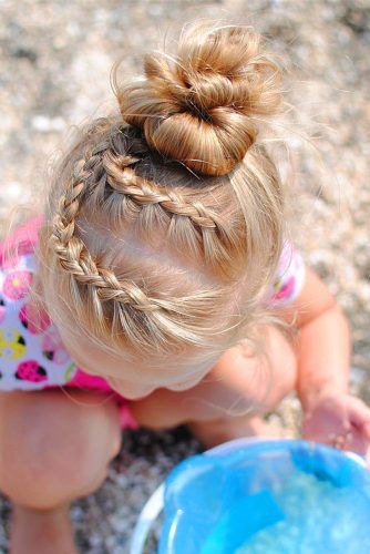 Girl with braided sections leading into a twisted top bun