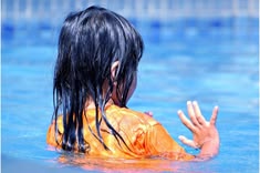 Child with wet hair swimming in a pool