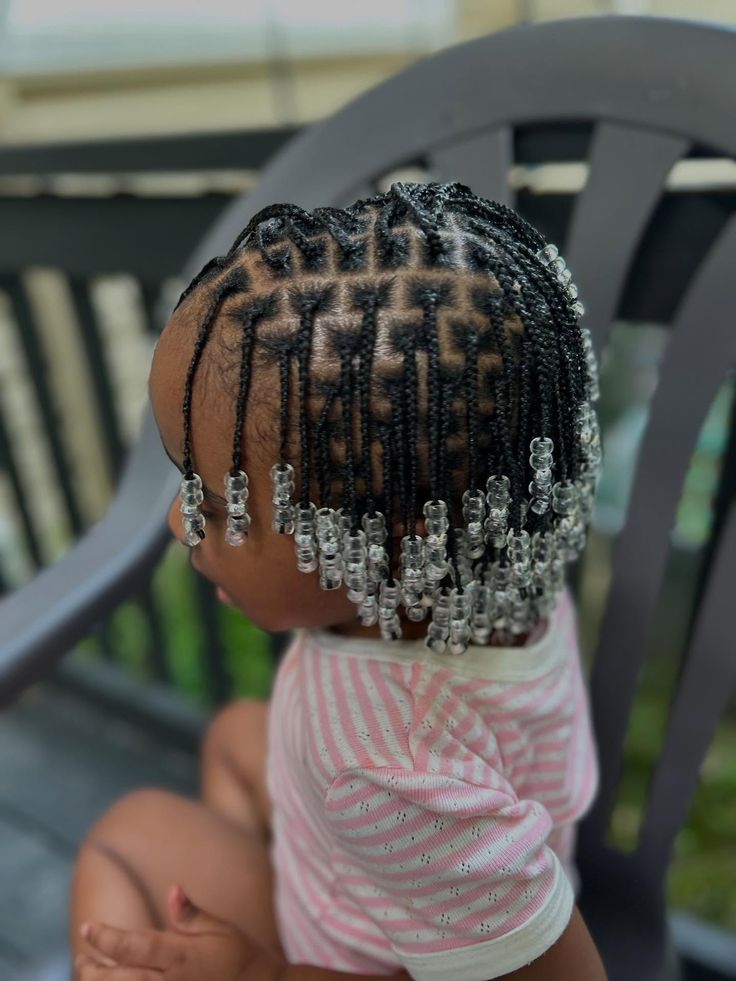 Child with mini braids and clear beads on the ends