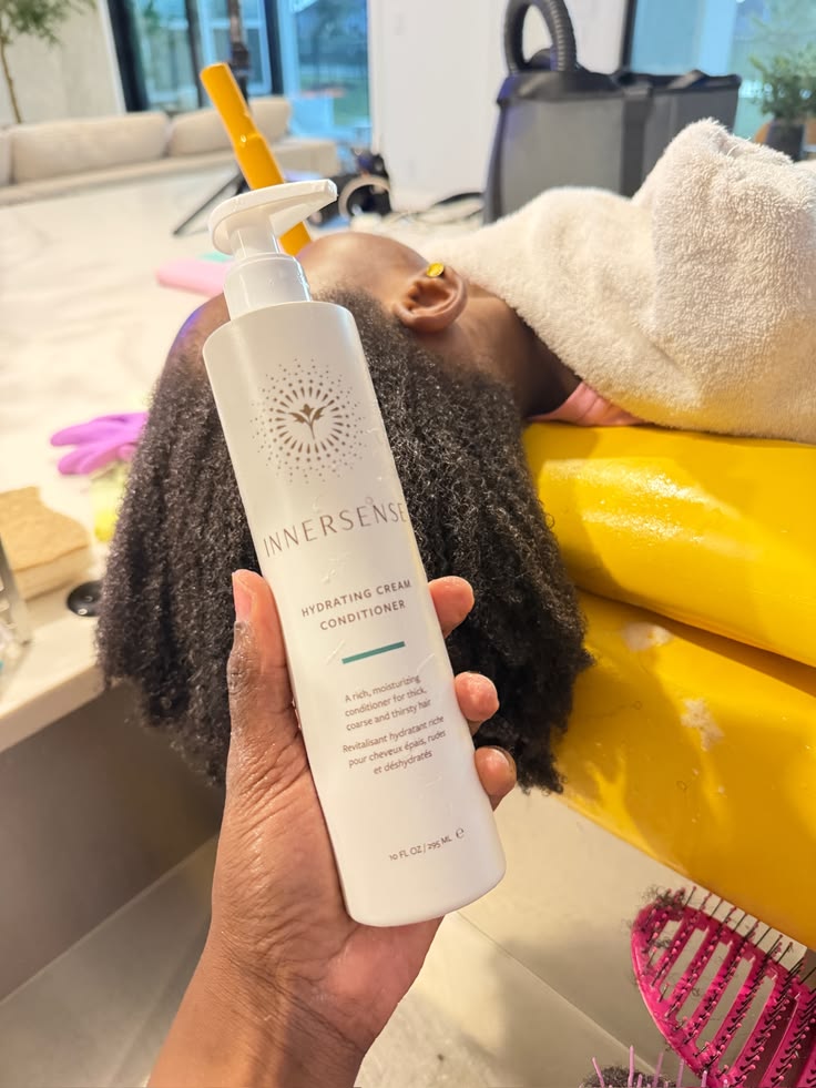 Innersense hydrating cream conditioner held near child's hair at wash basin