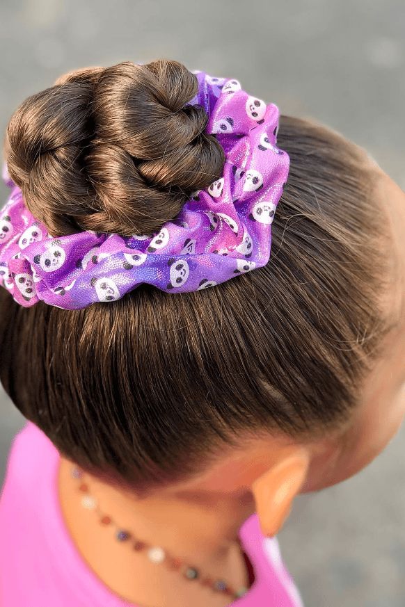 Girl with a high braided top knot secured with a purple panda print scrunchie