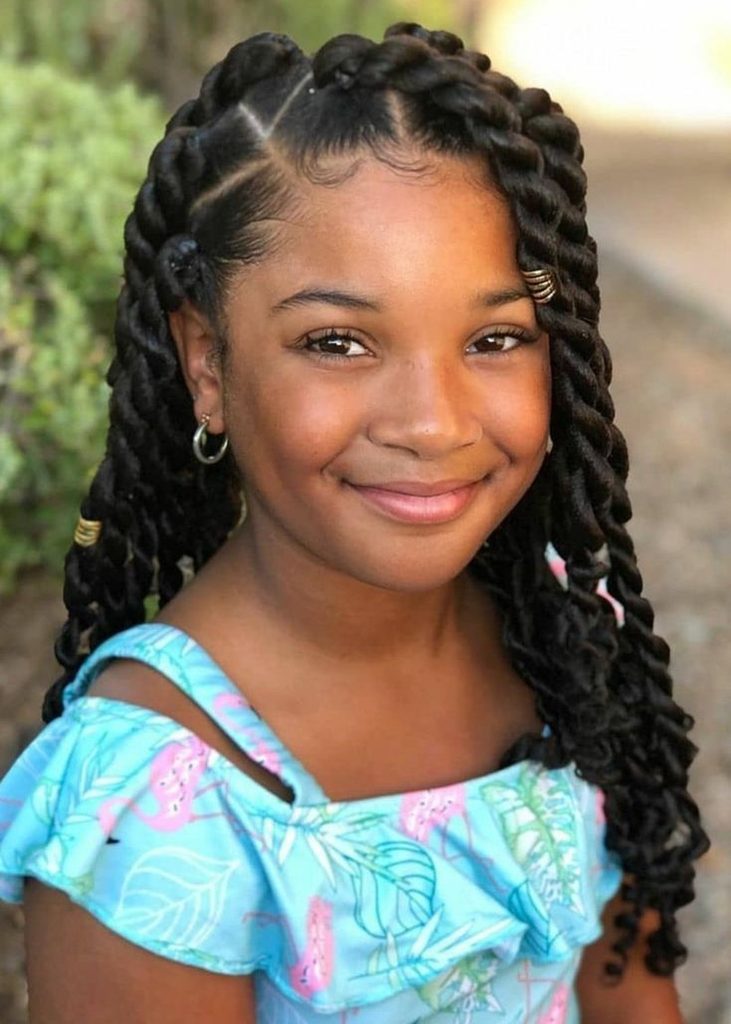 Young girl with neat protective twists styled down, smiling outdoors