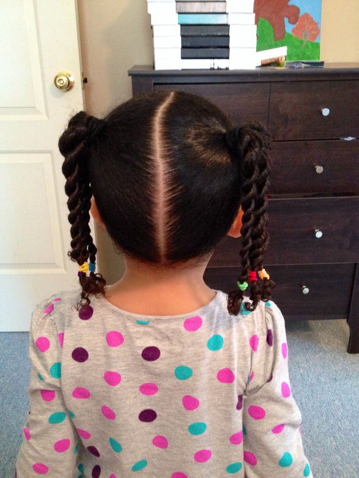 Girl with twisted pigtails secured with colorful elastics.