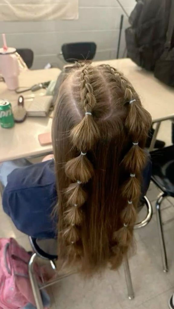 Girl with a half-up hairstyle featuring two braids that turn into bubble-sectioned strands over long loose hair