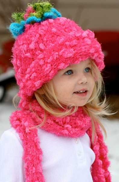 Smiling child in a pink winter hat and scarf