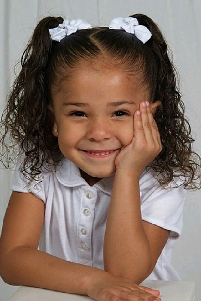 Girl with curly pigtails tied with white bows