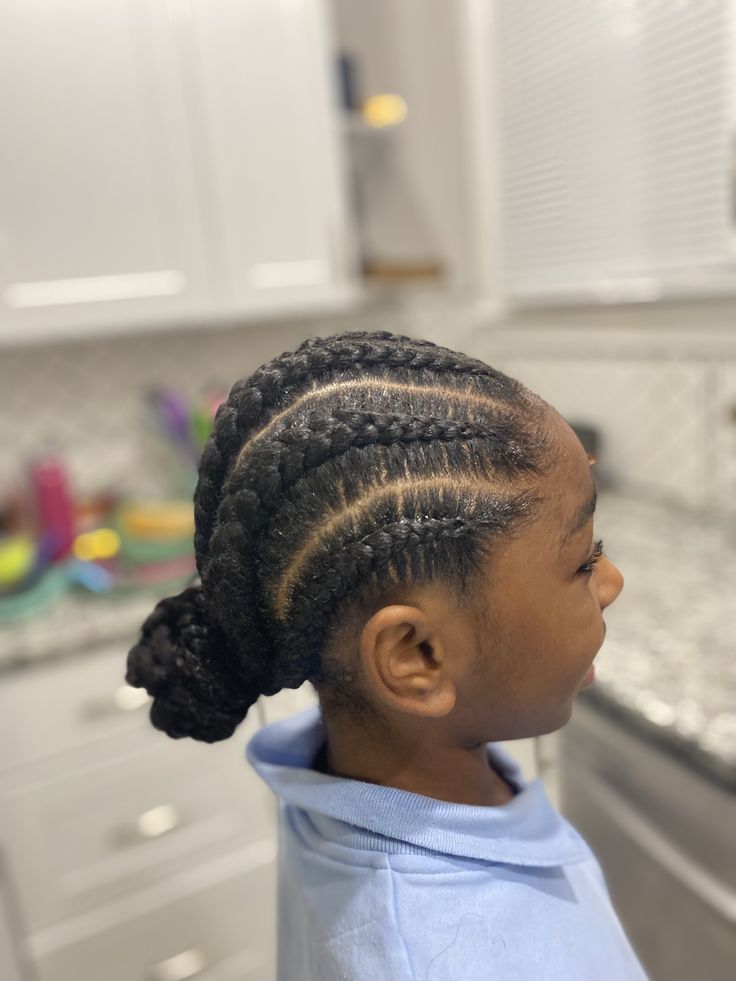 Close-up of a child's medium-sized cornrow braids pulled into a low bun.