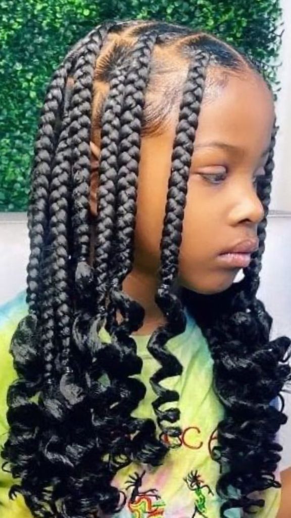 Close-up of a child's large, thick box braids with curled ends.